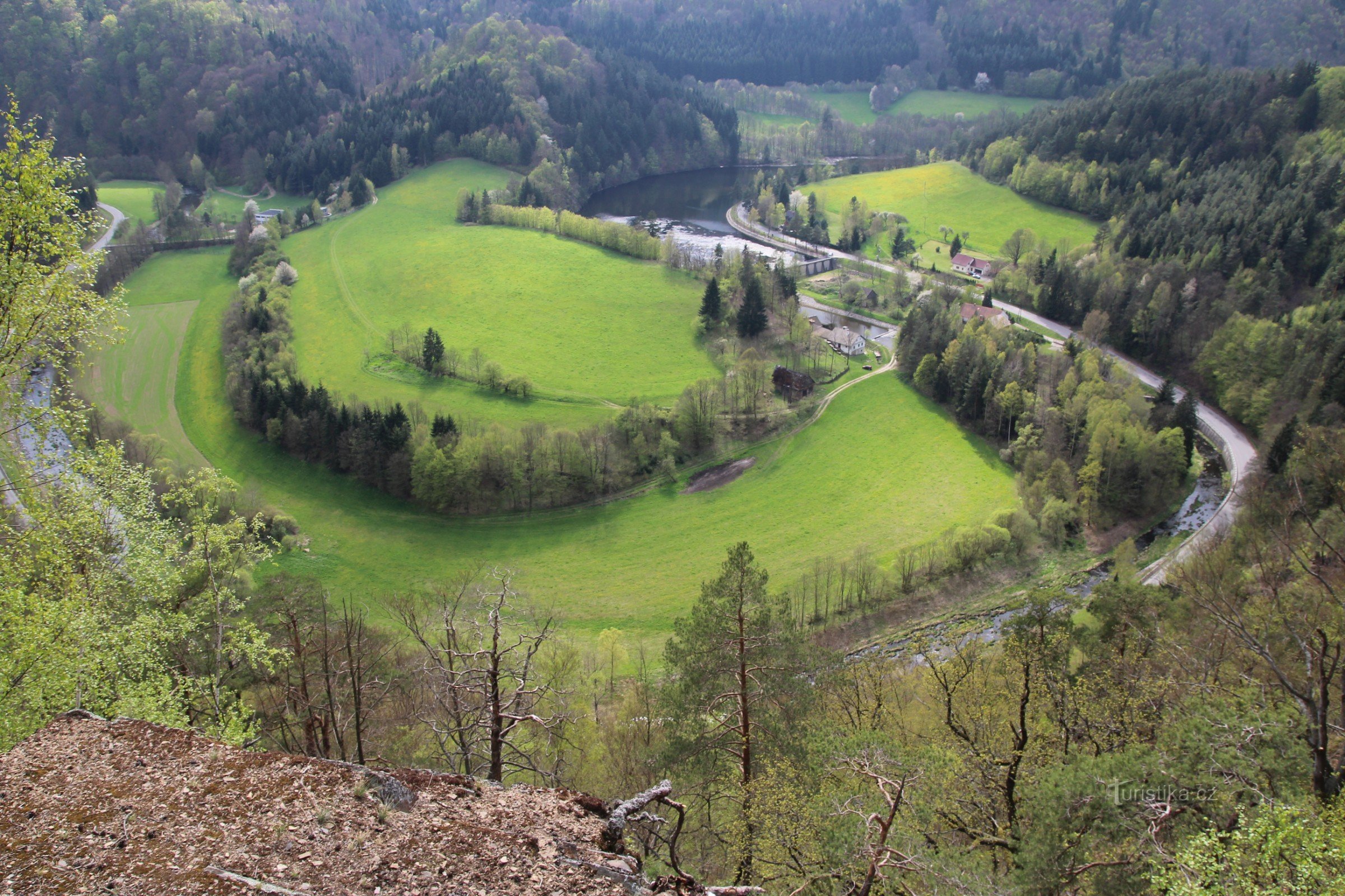 Pohled do údolí na široký meandr řeky Svratky, kterým prochází podzemní přivaděč