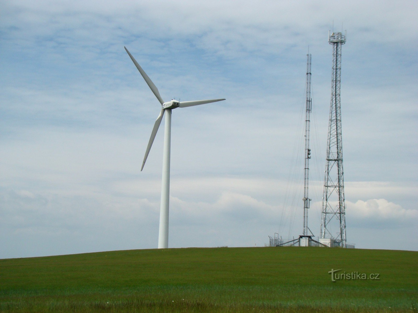 Vrchol kopce se dvěma vysílači jednou ze dvou větrných elektráren