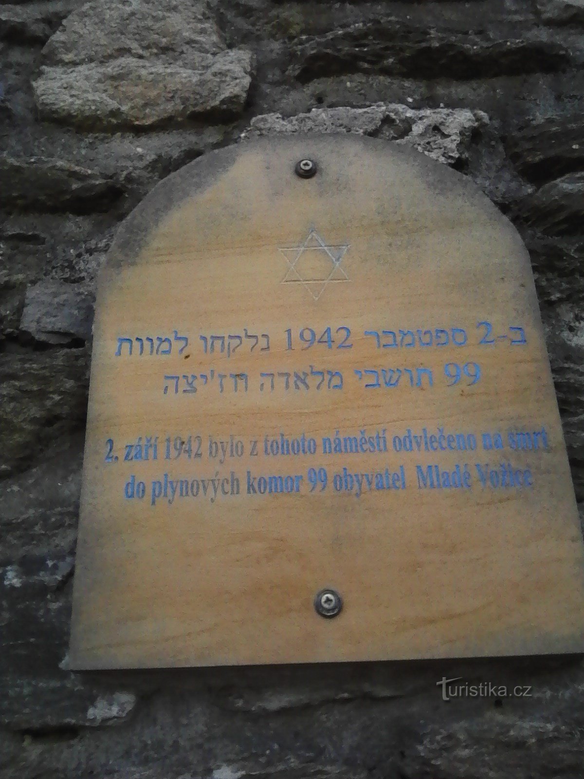 1. O placă care comemorează ororile războiului pe zidul din fața bisericii