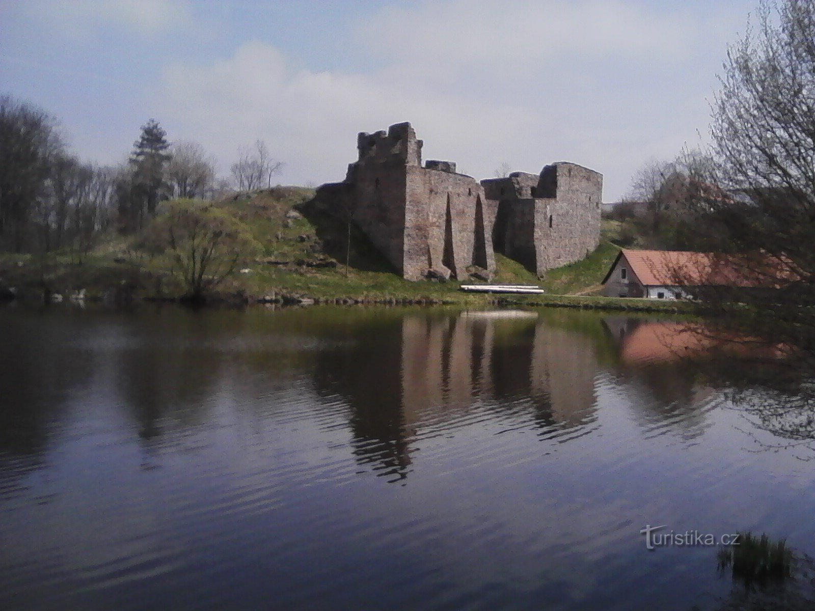 1. Zbytky hradu se zhlížejí na hladině rybníka.
