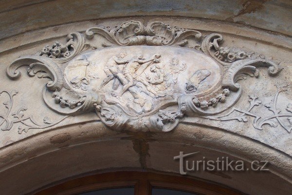 2. Cartouche au-dessus de la façade de la maison - une scène du chemin de croix