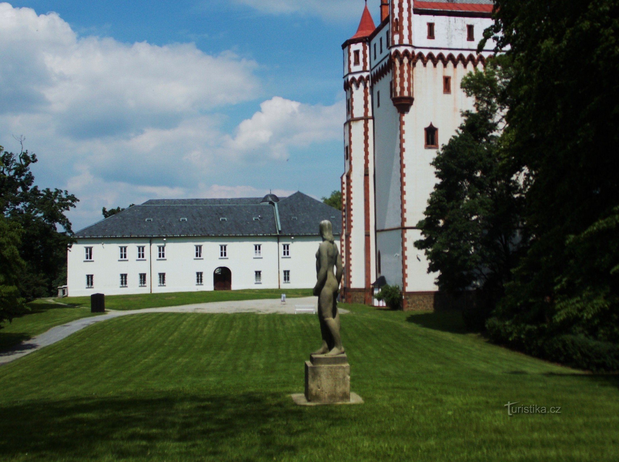 Белая водонапорная башня в замковом парке в Градец-над-Моравици