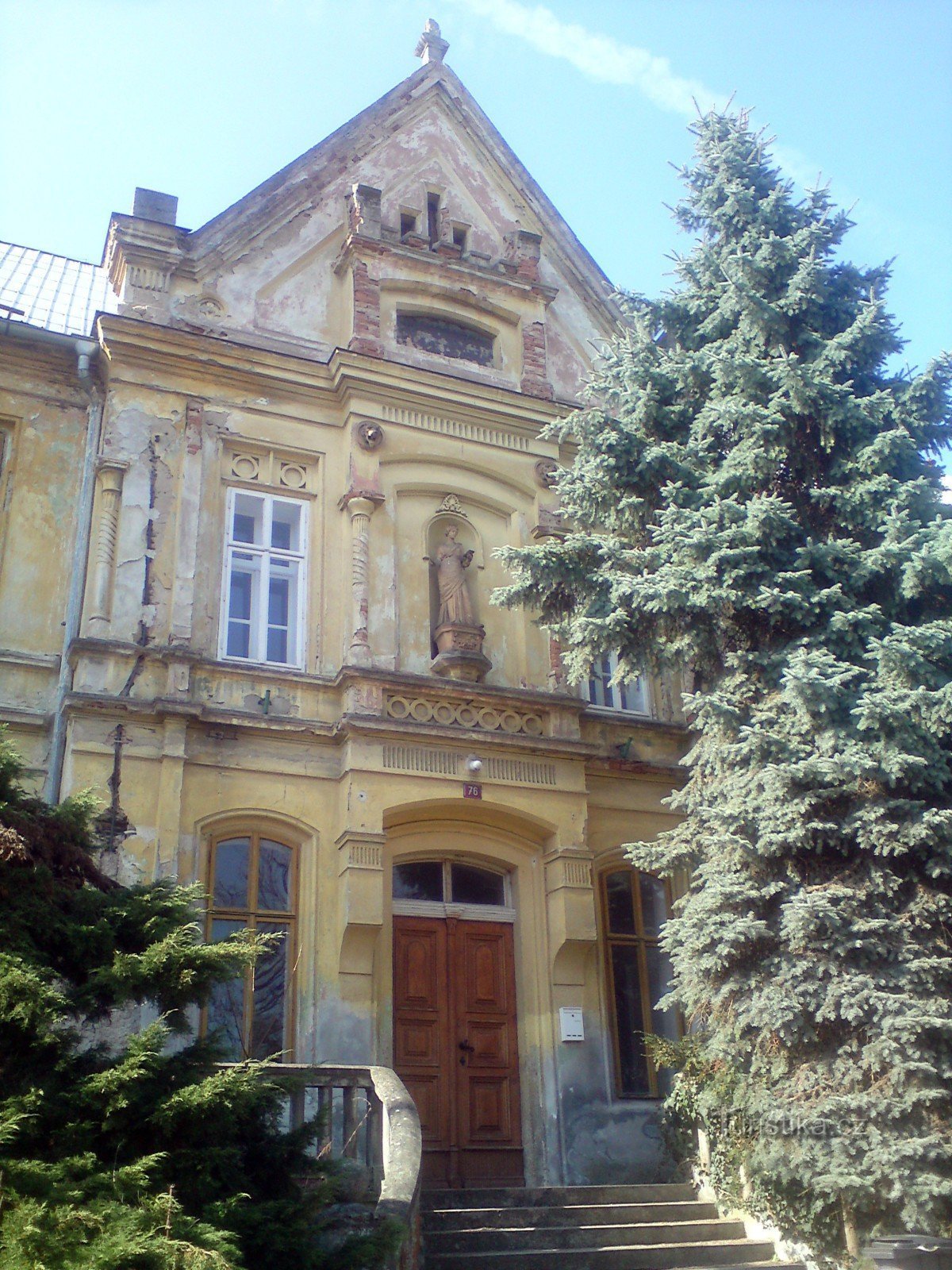 la façade et l'entrée principale du bâtiment de l'école - un sapin argenté à droite orne l'escalier, non