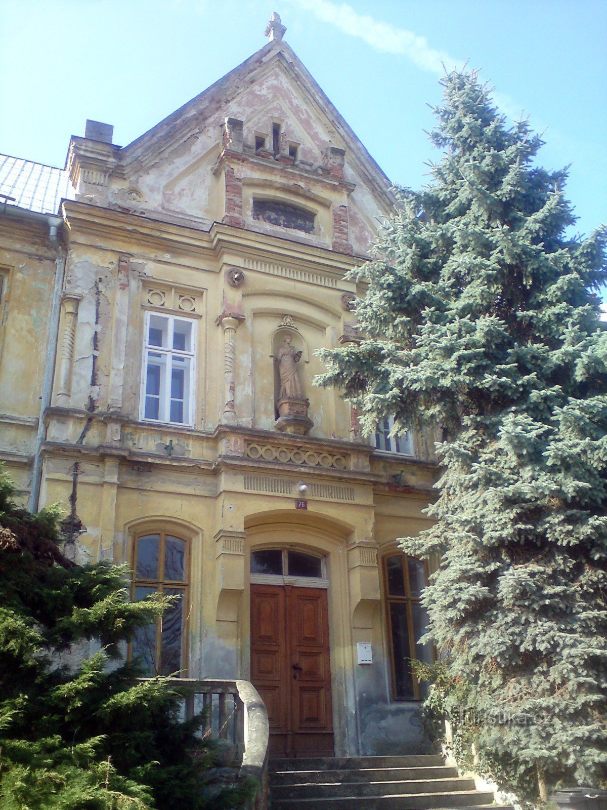 the front and the main entrance to the school building - a silver spruce to the right decorates the staircase, no