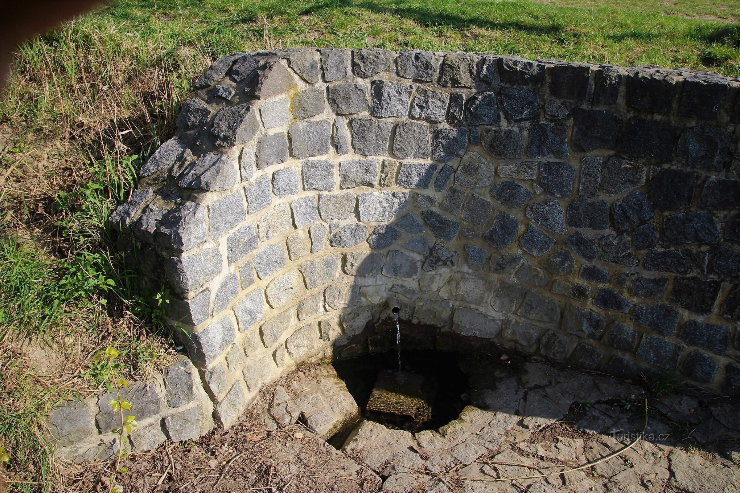 Čelo vodnjaka je zgrajeno iz obdelanega lomljenega kamna