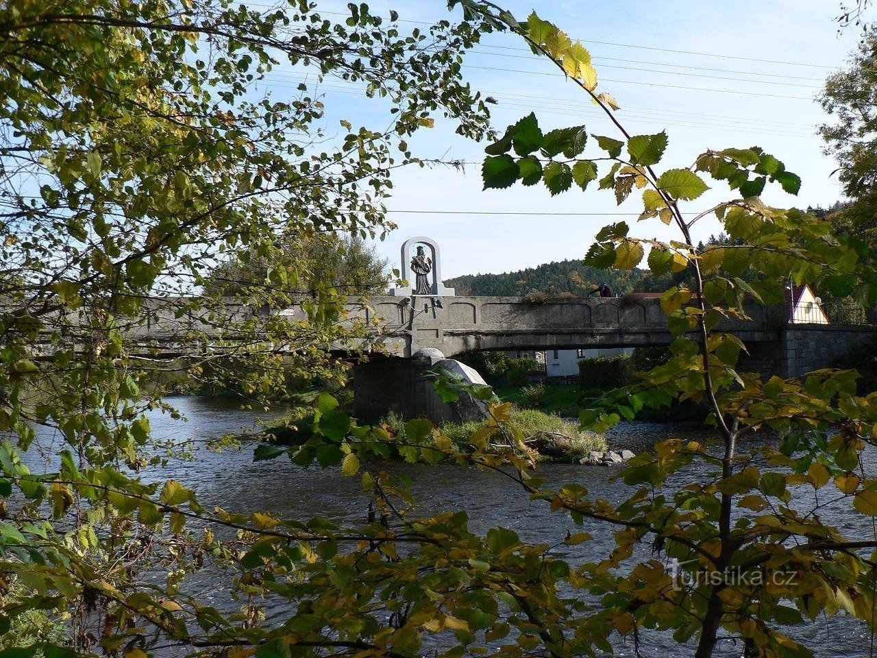 Кепка, вид на мост и статую с левого берега