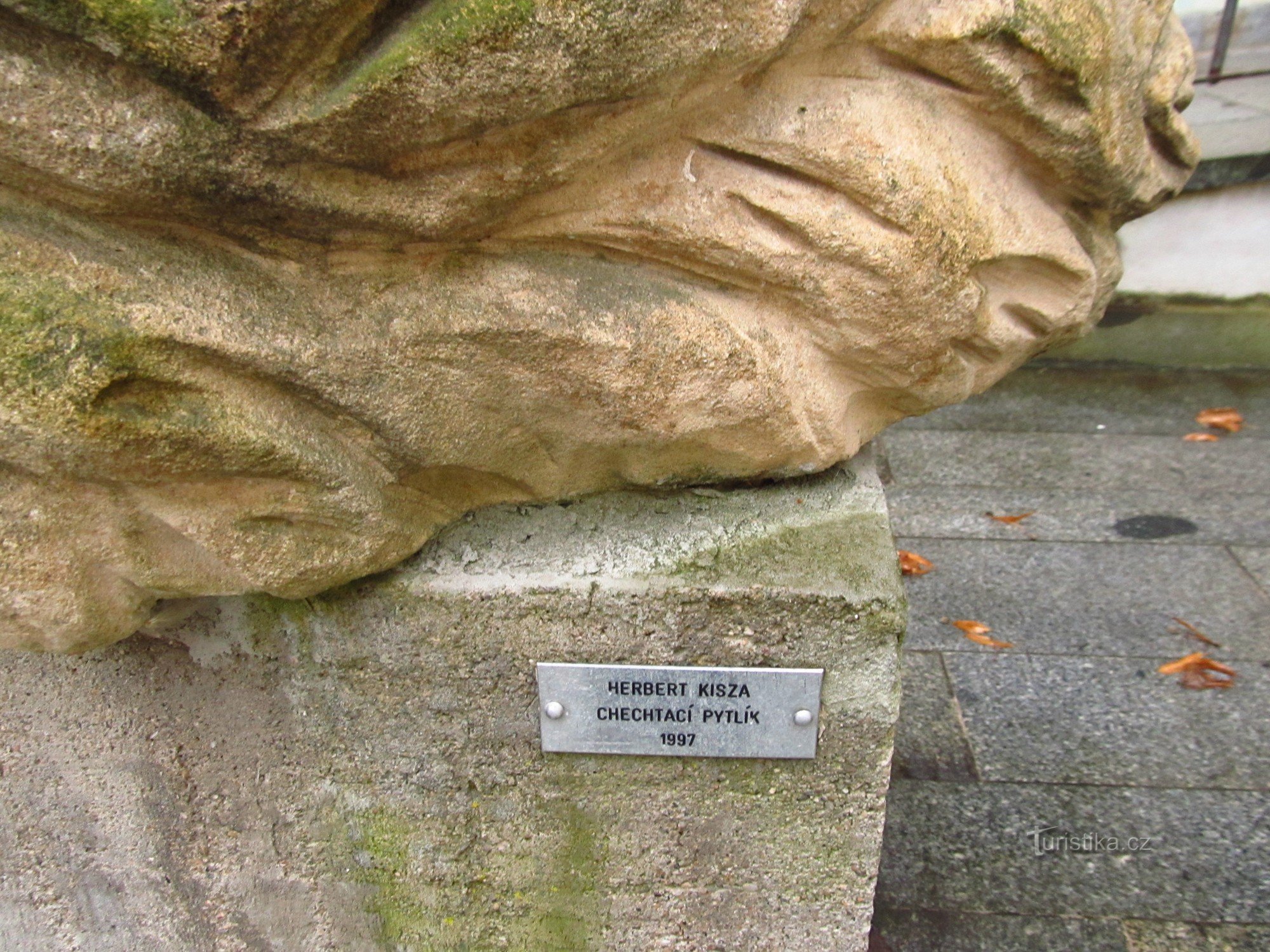 Latterpose - en skulptur af Herbert Kisza på bymuren i Kadaň