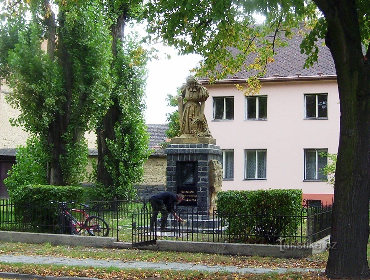 Chvalkovice-Selské náměstí-monumento a las víctimas de la Guerra Mundial con una estatua de Hanačka y relé