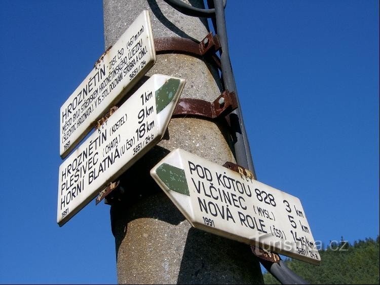 Signpost detail: A green marked path leads south to the center of the village, prez