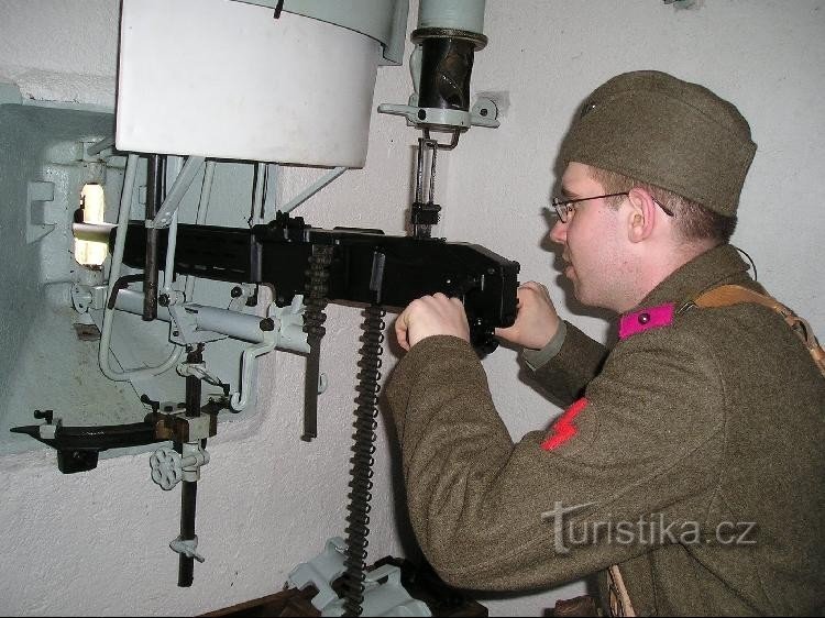 A soldier in period uniform firing barrage fire from a heavy machine gun vz. 37