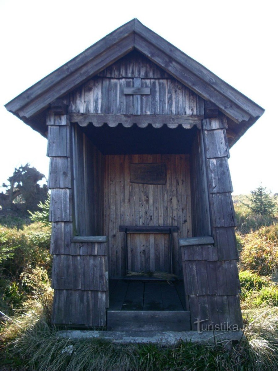 A wooden chapel in front of the hunting lodge