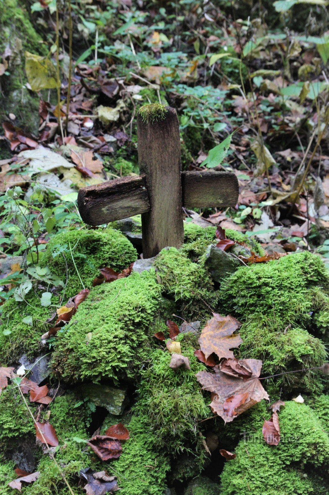 Ein Holzkreuz unter einer Felswand