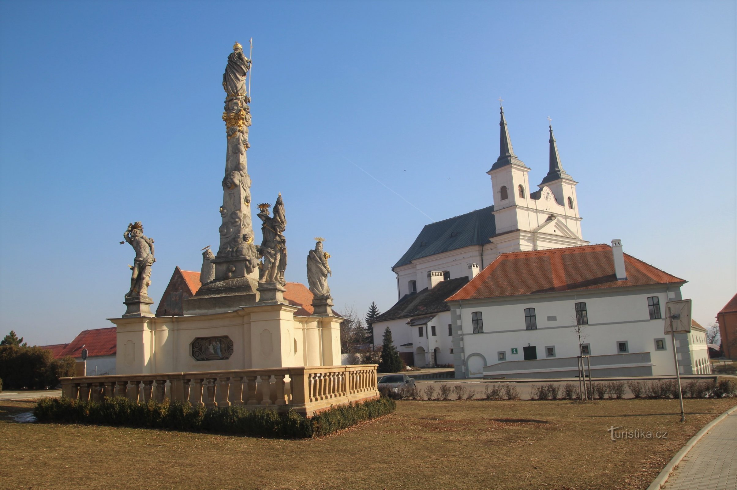 Drnholecké náměstí con la colonna mariana, il vecchio municipio e la chiesa della Santissima Trinità