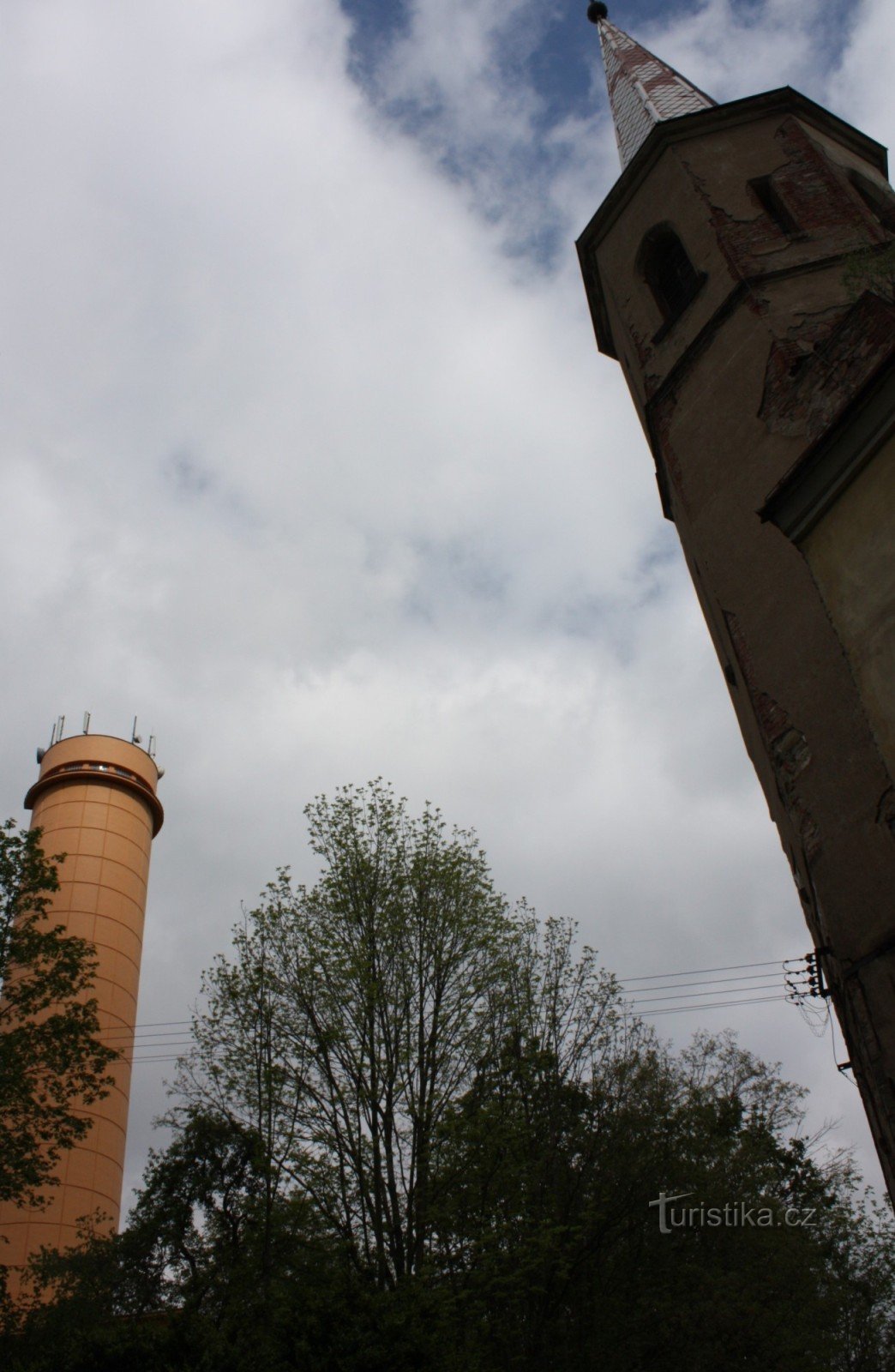 Two landmarks of the settlement of Práčov - the church and the water tower