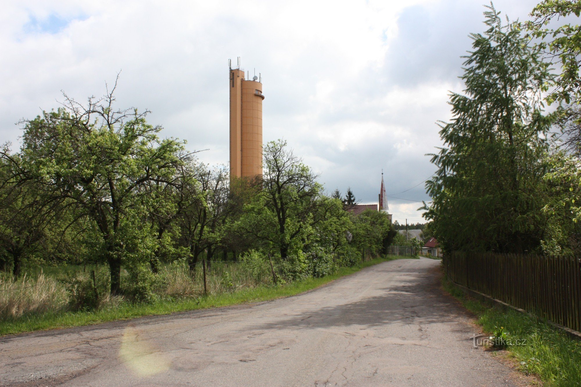 Two landmarks of the settlement of Práčov - the church and the water tower