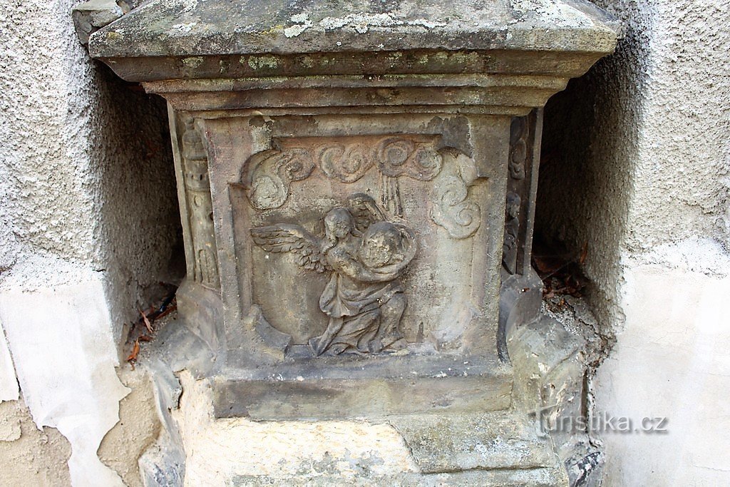 Tumba, relieve en la base de la estatua