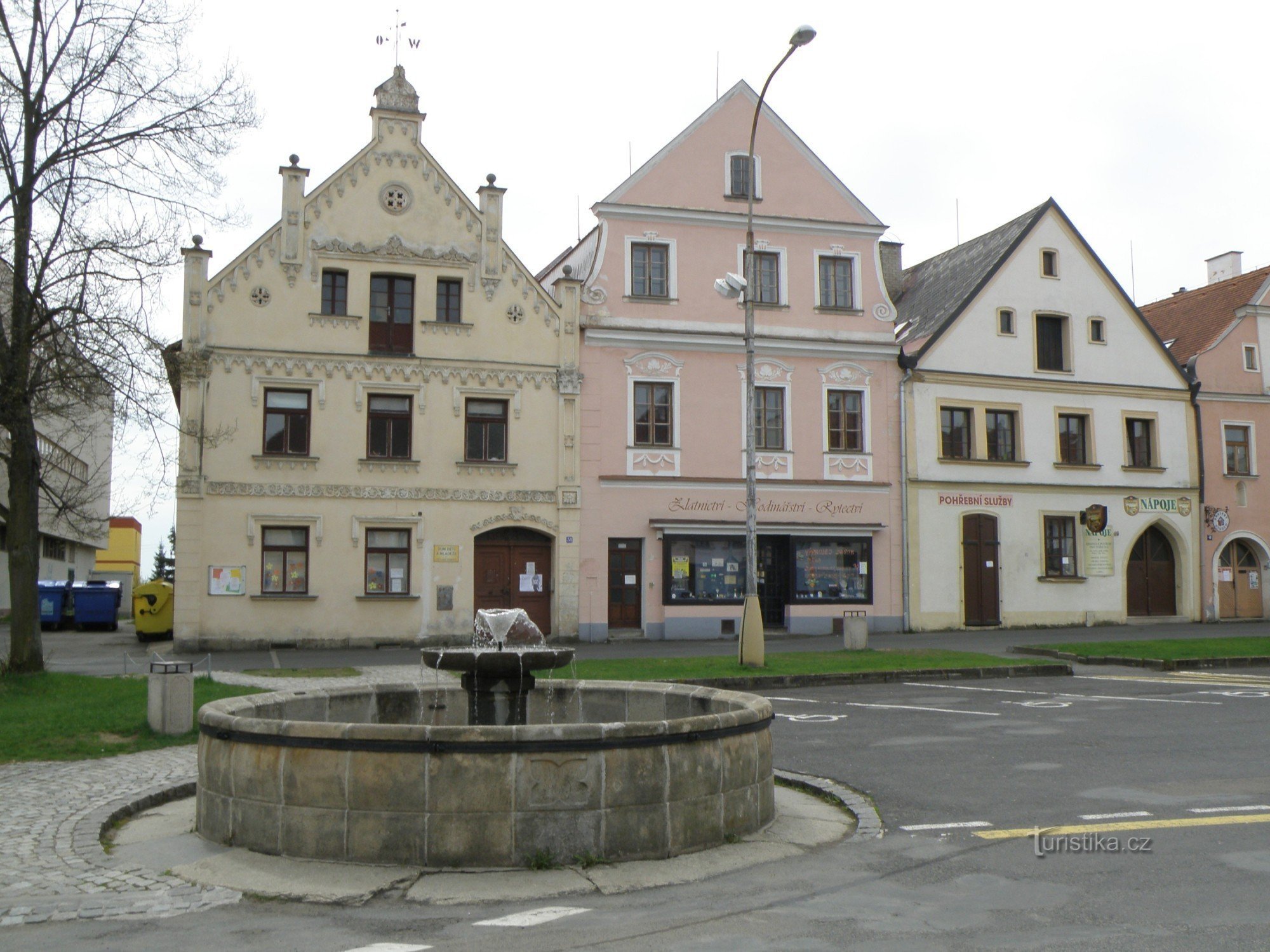 einer von sechs Brunnen mit historischen Häusern im Hintergrund