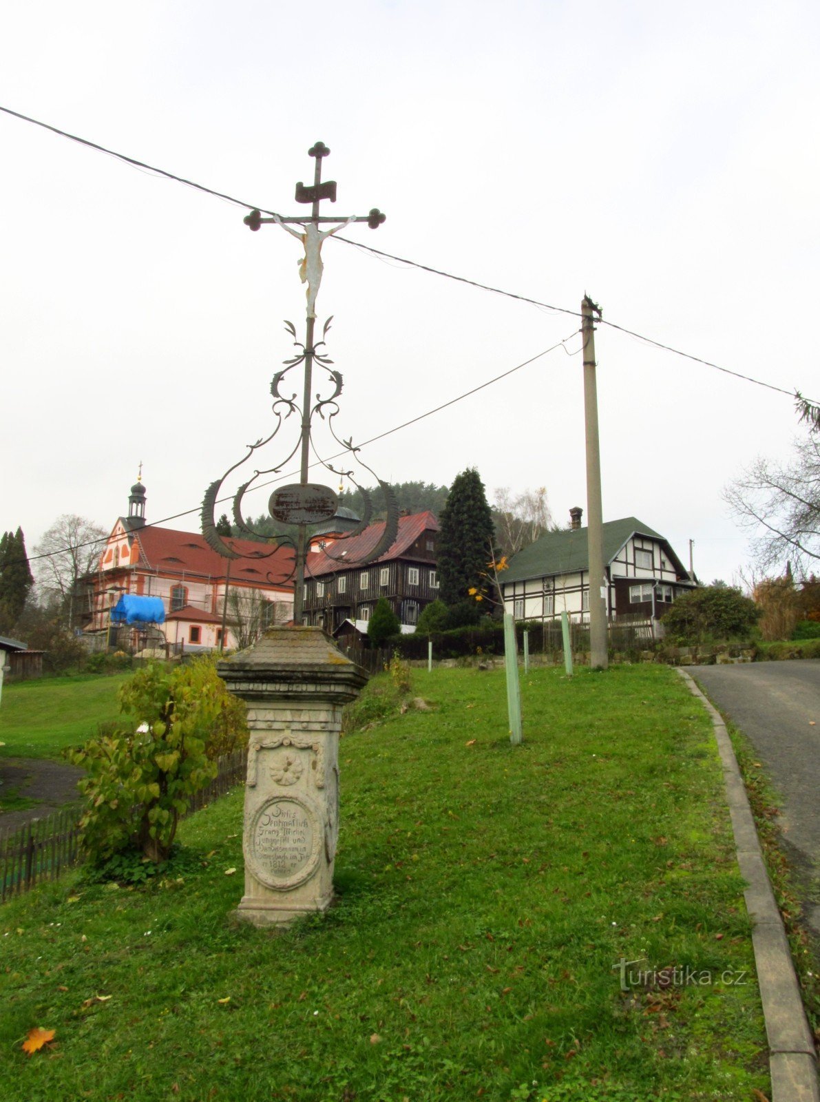 Jetřichovice-křížek mit Kirche und Pfarrhaus im Hintergrund