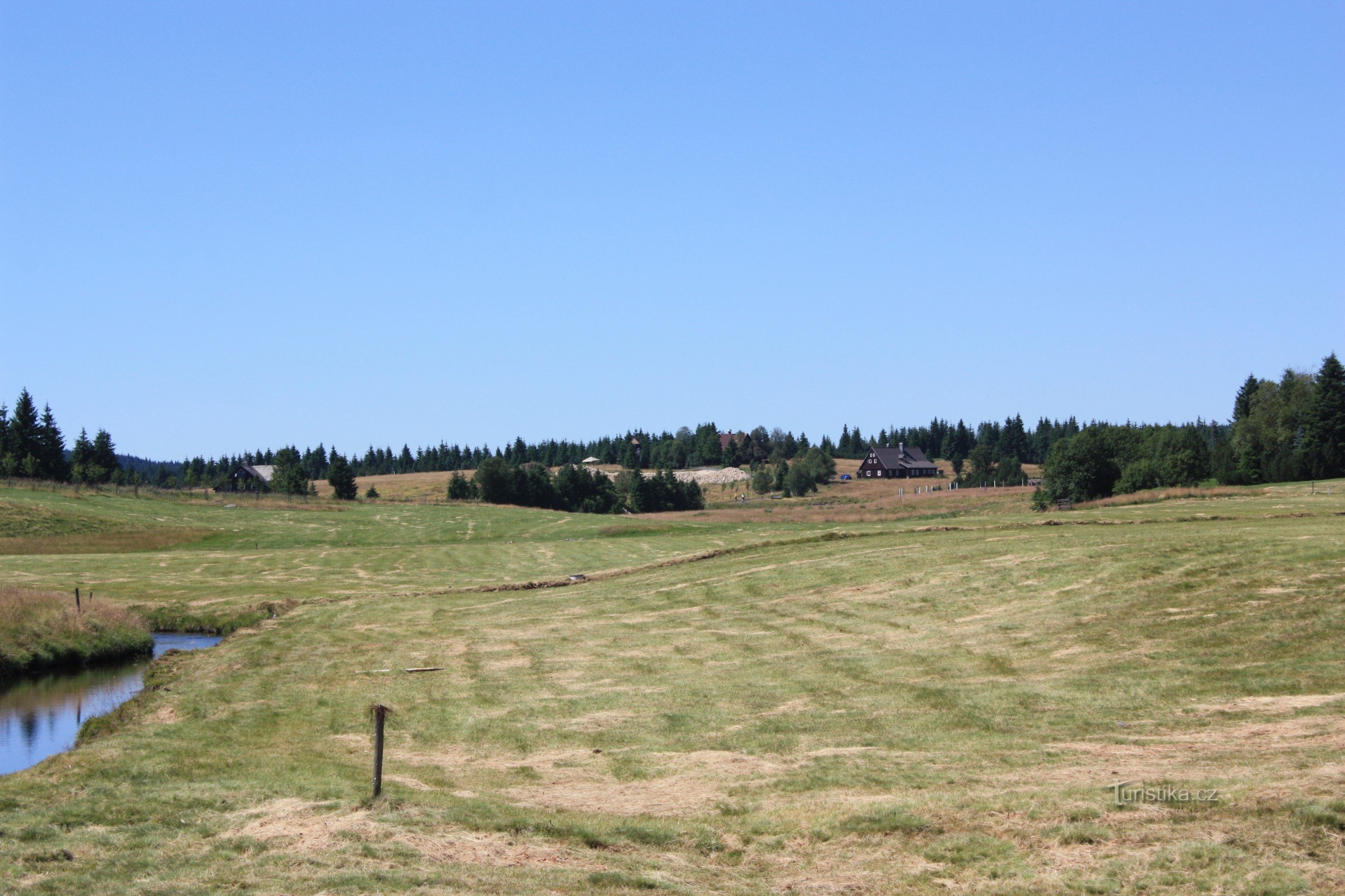 Jizerka con la casa de estiércol al fondo