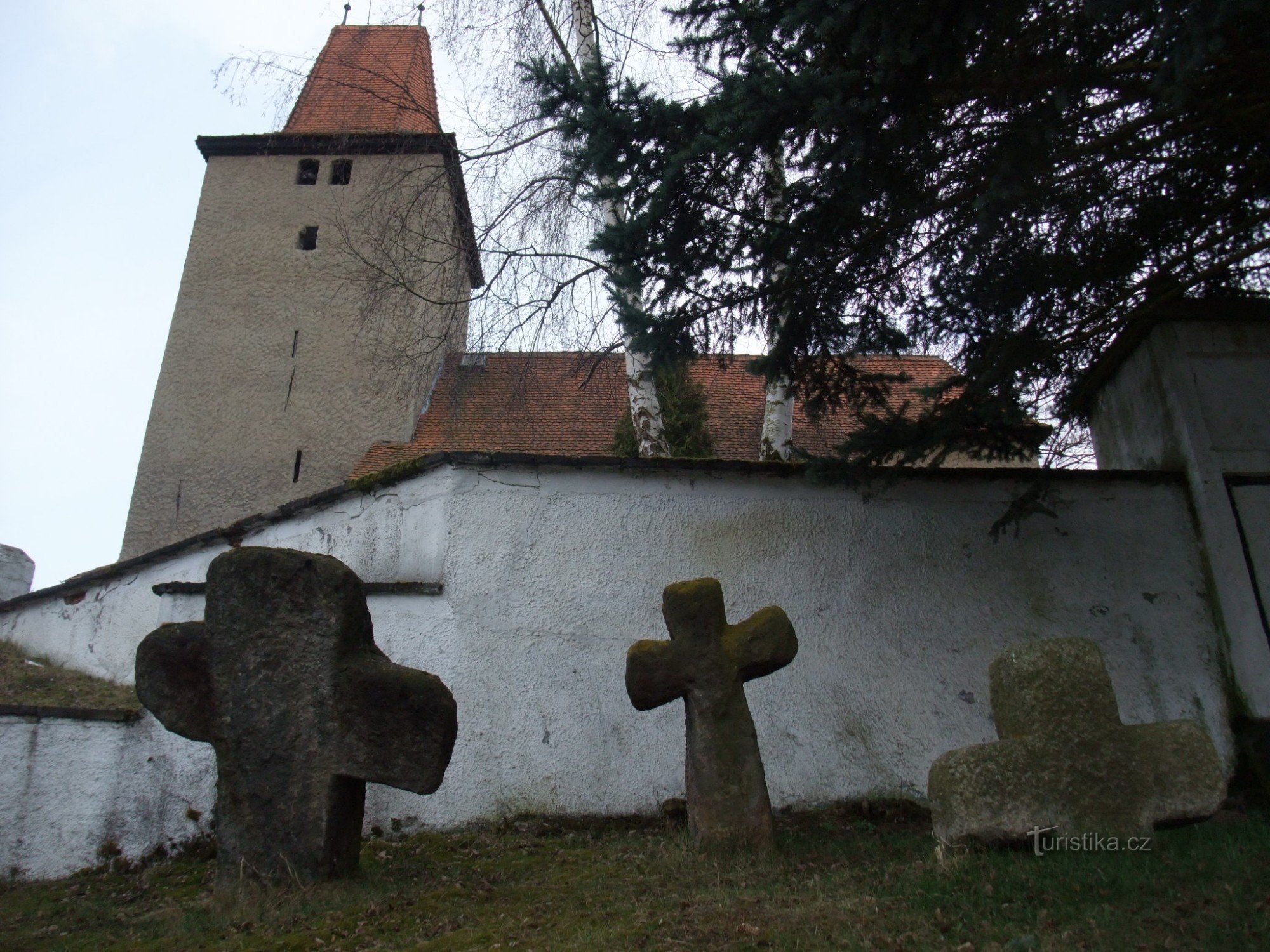 кам'яні хрести біля стіни цвинтаря