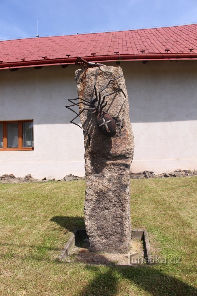 Un pilar de piedra con una araña.