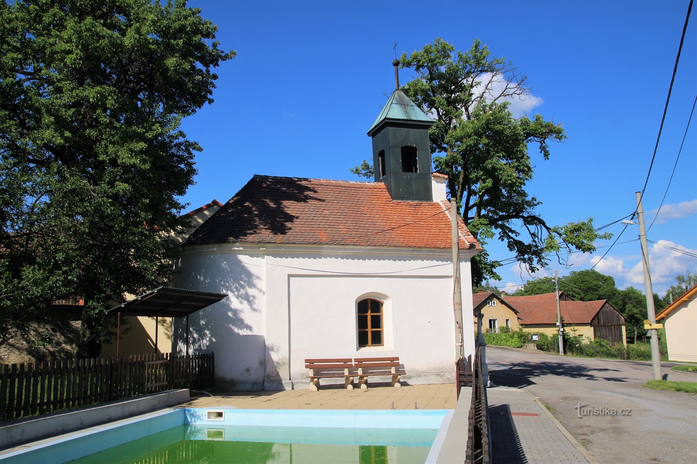 Chapelle de l'Assomption de la Vierge Marie dans le village avec un réservoir d'eau