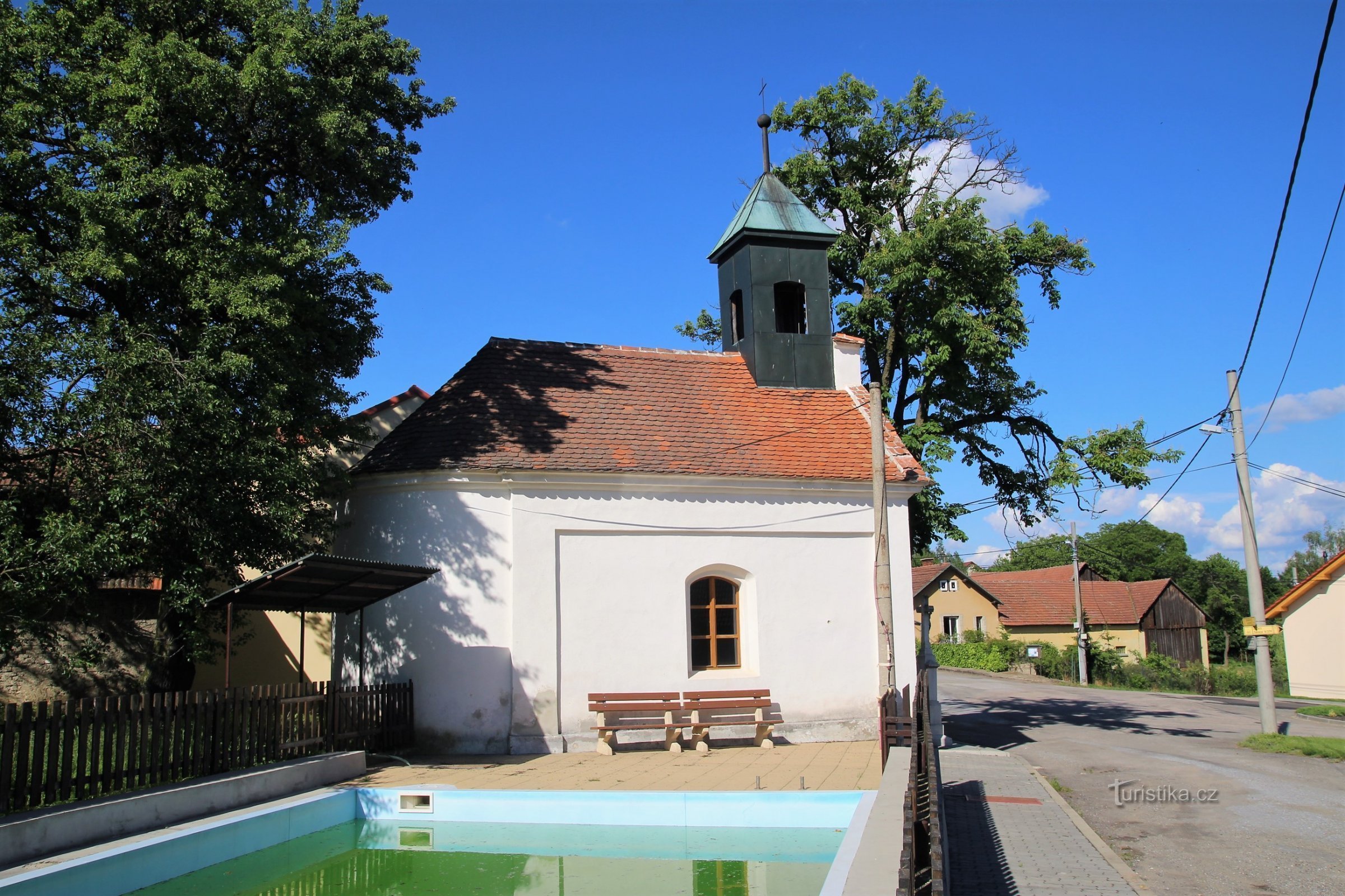 Capilla de la Asunción de la Virgen María en el pueblo con depósito de agua