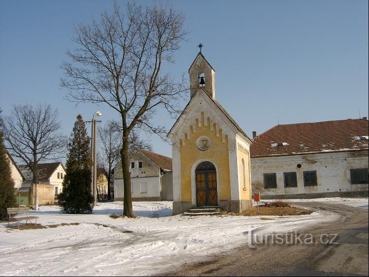 Dřevecの村のチャペル: レンガ造りの礼拝堂で、端が三角形で、ファサードの上に鐘楼があります。
