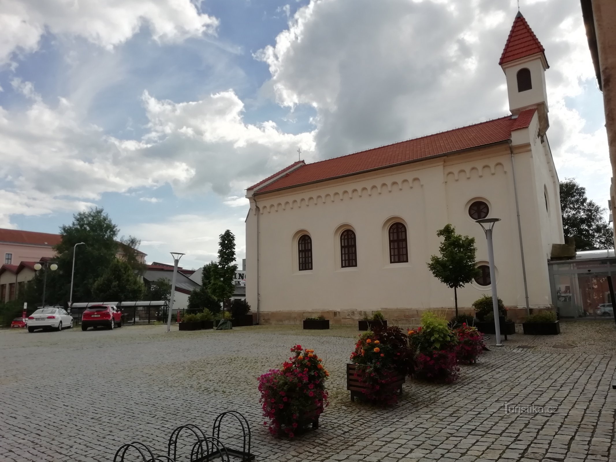 kápolna, virágok az egykori magtár előtt