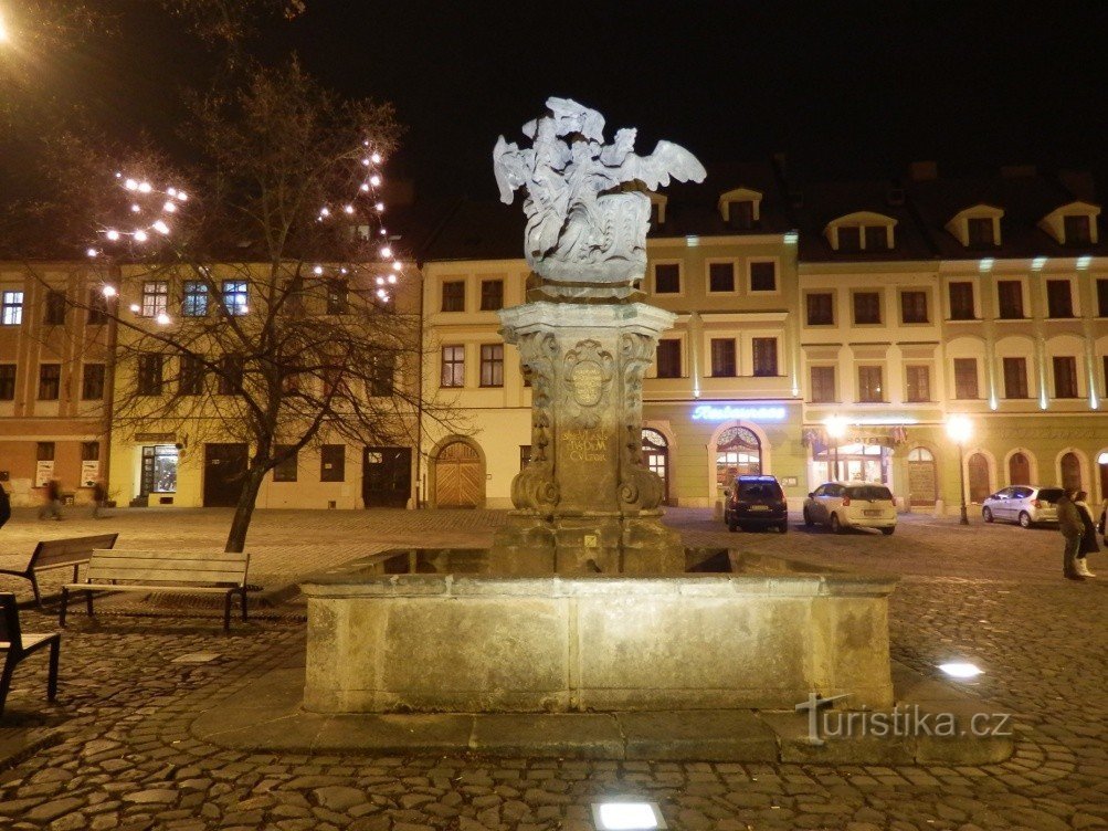 Una fontana con una scultura di notte