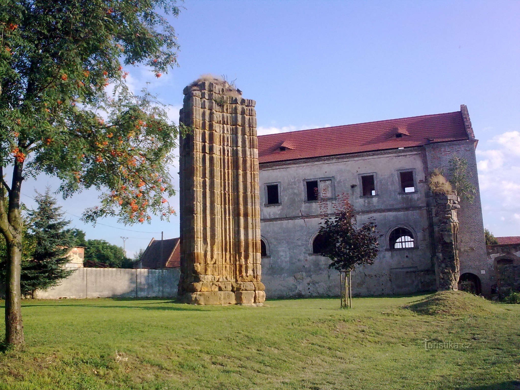 Klášterní Skalice - 修道院の柱、背景には城のある中庭