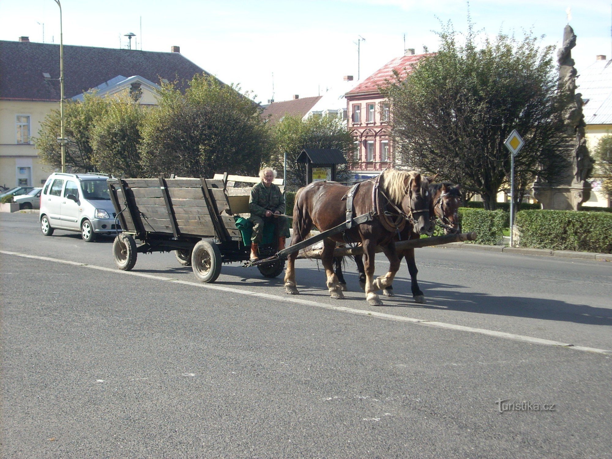 Ruiters uit een koets die over het plein rijdt