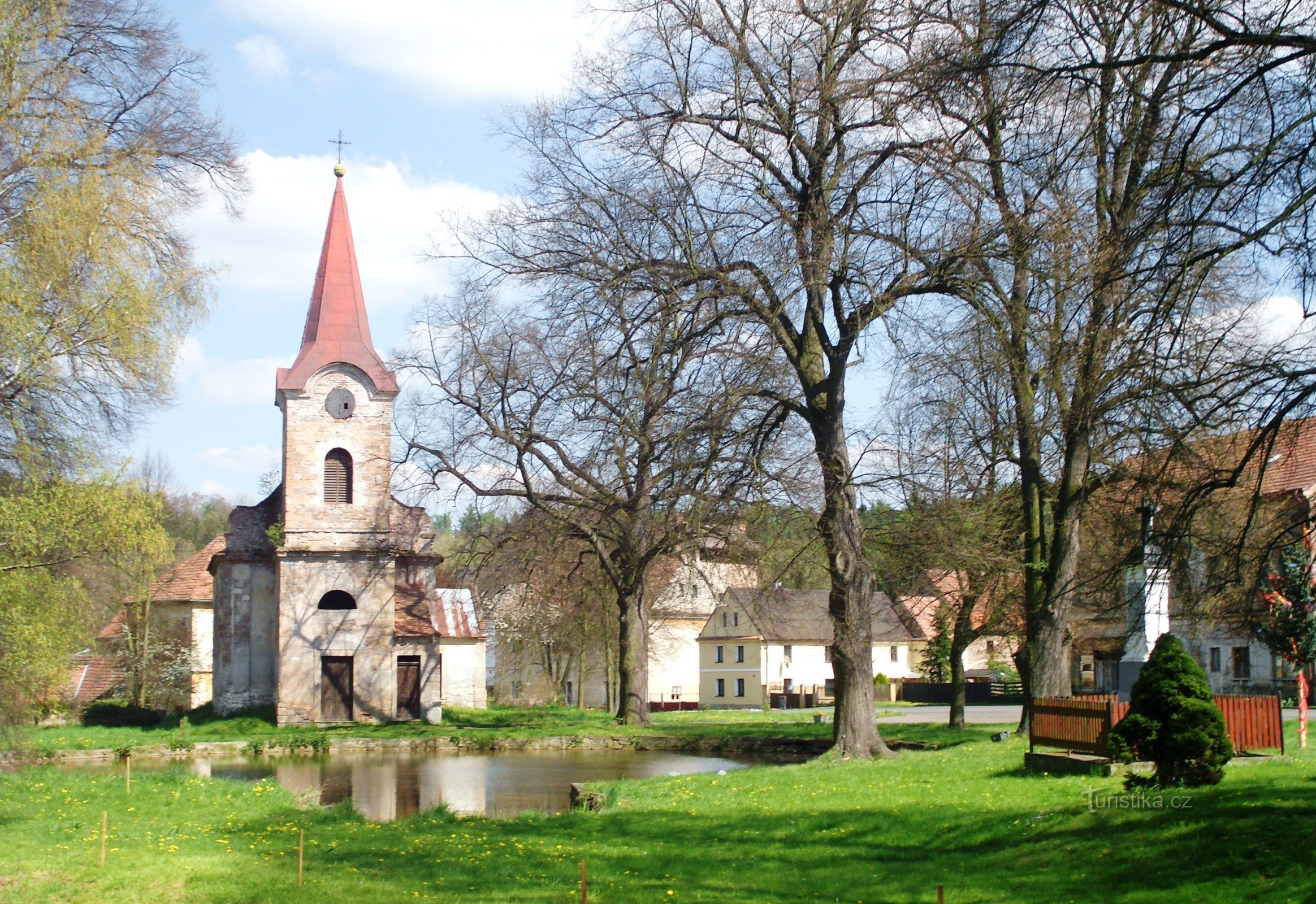 Die Kirche befindet sich im Dorf hinter dem Teich - Blick von Westen