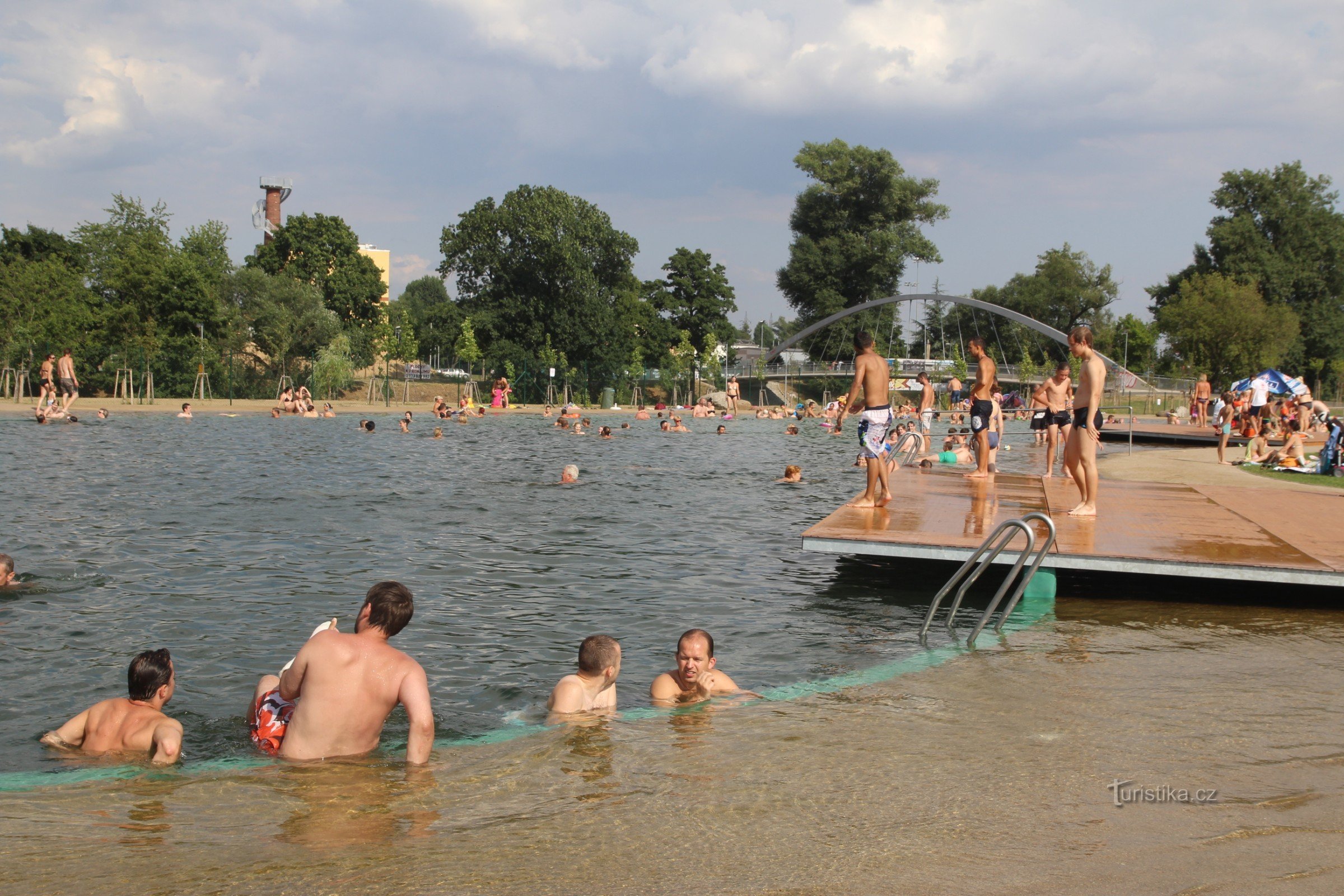 Basen znajduje się w pobliżu nowego mostu rowerowego nad rzeką Svratka, w tle