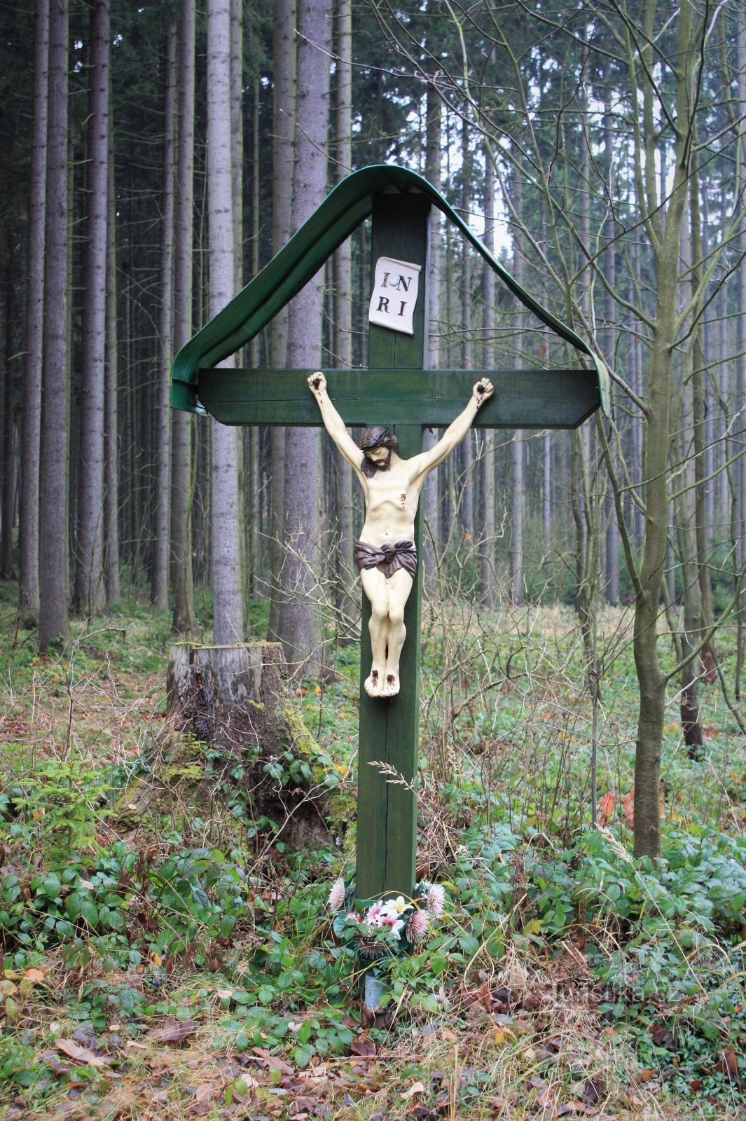 Puțin mai jos de fântână se află și o cruce de lemn