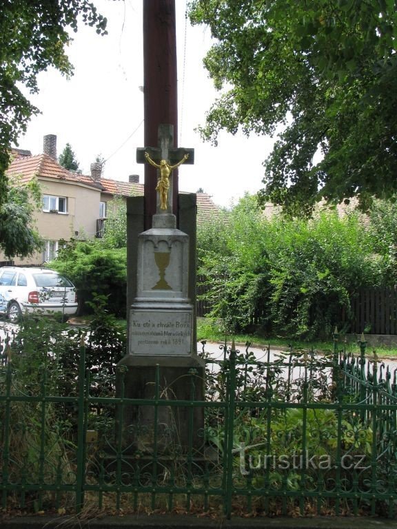 A cross and a belfry in the village... It shows both a crucified Christ and a Hussite chalice