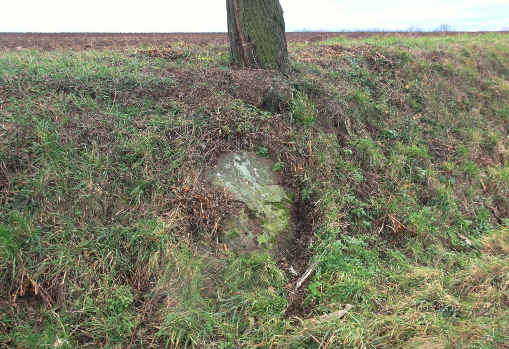 Cross stone on the hillside by the road