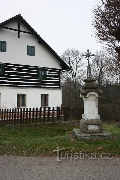 Crucifix devant un bâtiment avec un plancher en bois