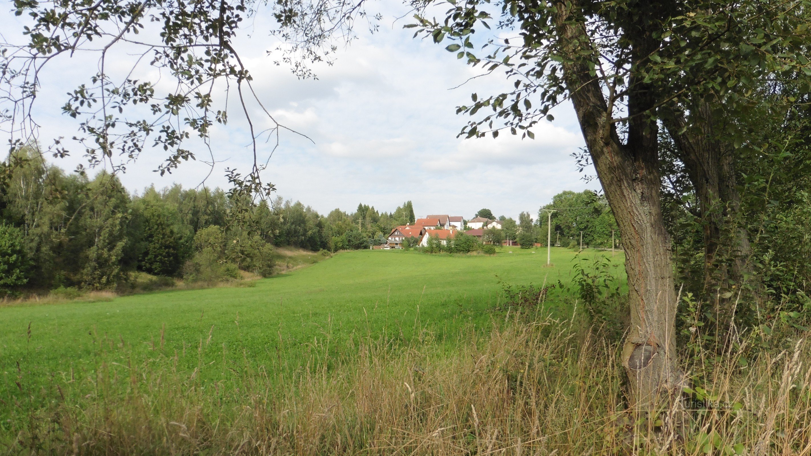 Kvasetice, uitzicht vanaf de weg vanuit Michalovice, links een bos met een graftombe