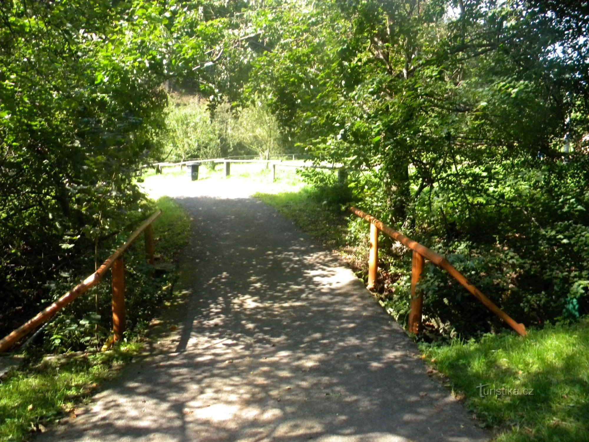 Fußgängerbrücke am Wäldchen in Perštejnec, Eingang zum Weg zum Schloss