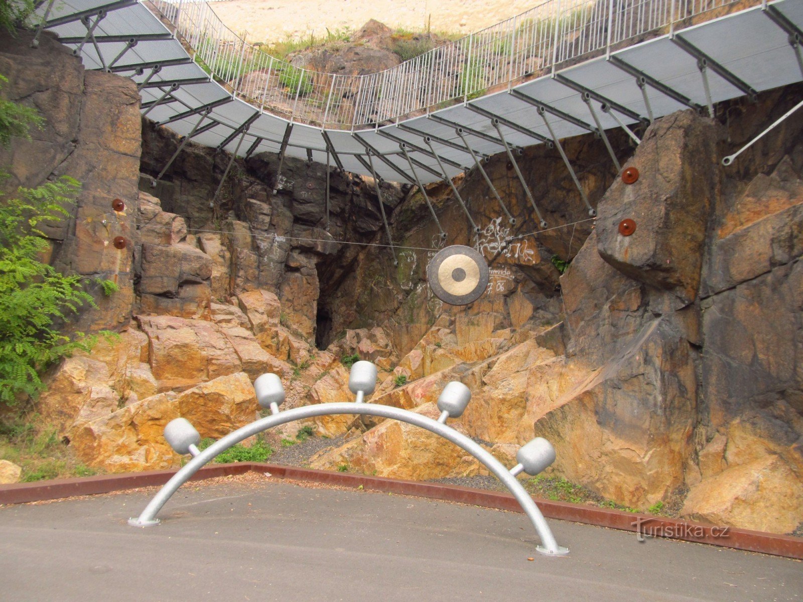 Víta Brandy footbridge in Kadani - a view from below of the metal footbridge attached to the rock