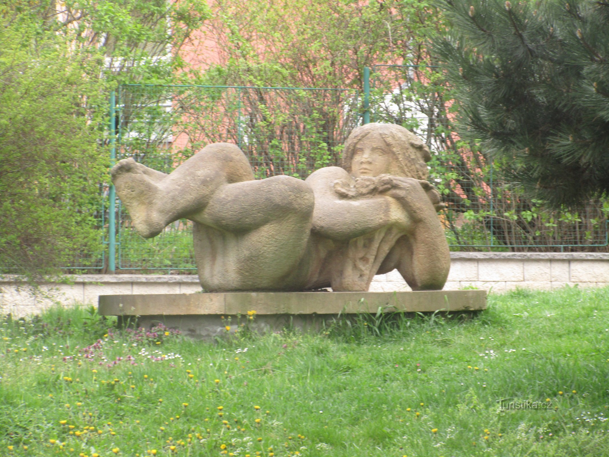 Liegende Frau vor dem Kindergarten