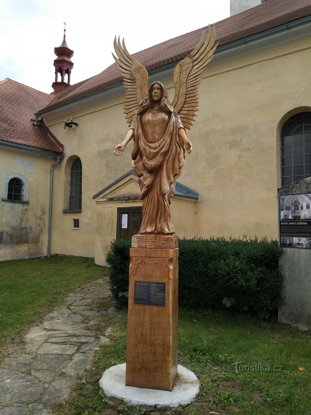 Îngerul Malšín în fața bisericii