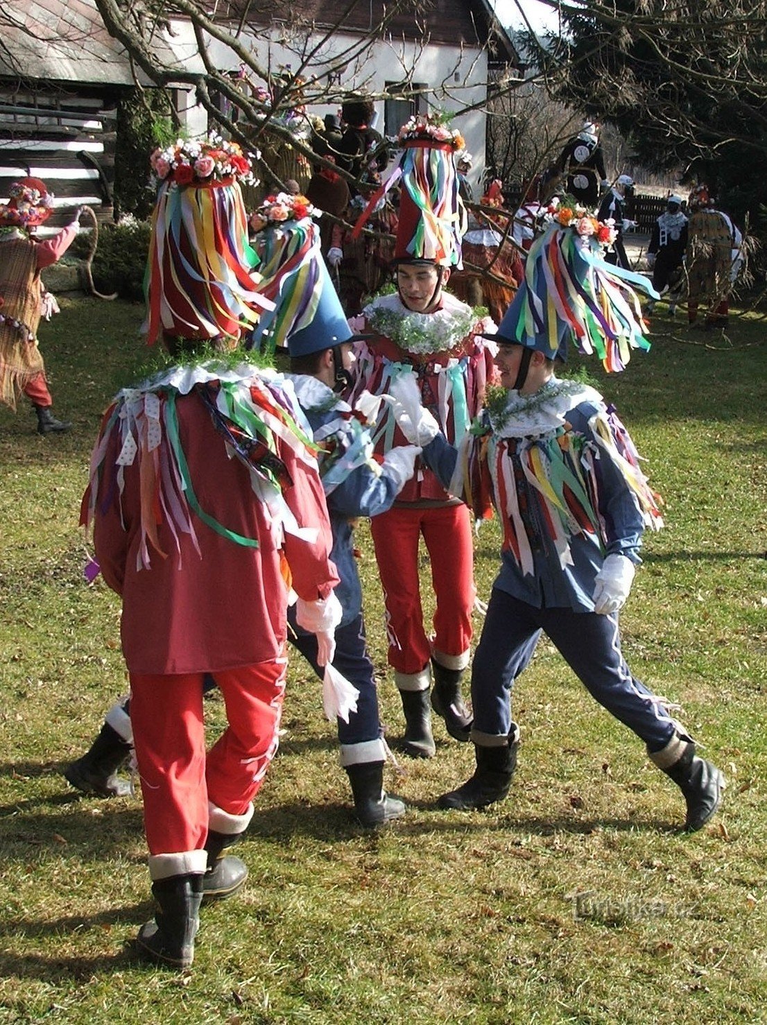 Πηδώντας Μάσκες χορεύουν μπροστά σε κάθε σπίτι του χωριού