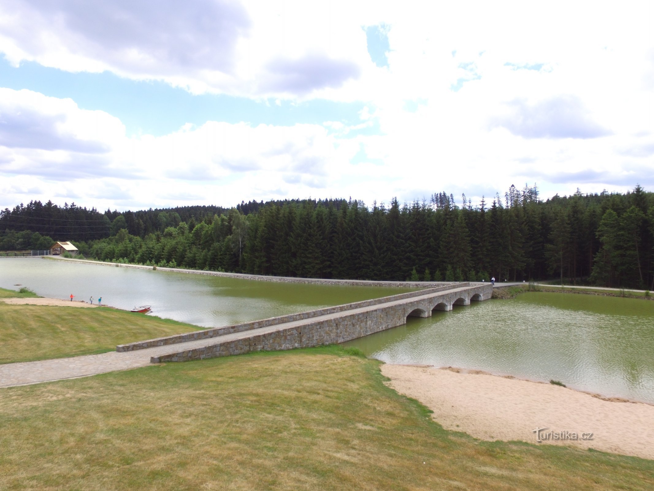 pont sur le réservoir artificiel jusqu'à la maison d'hôtes