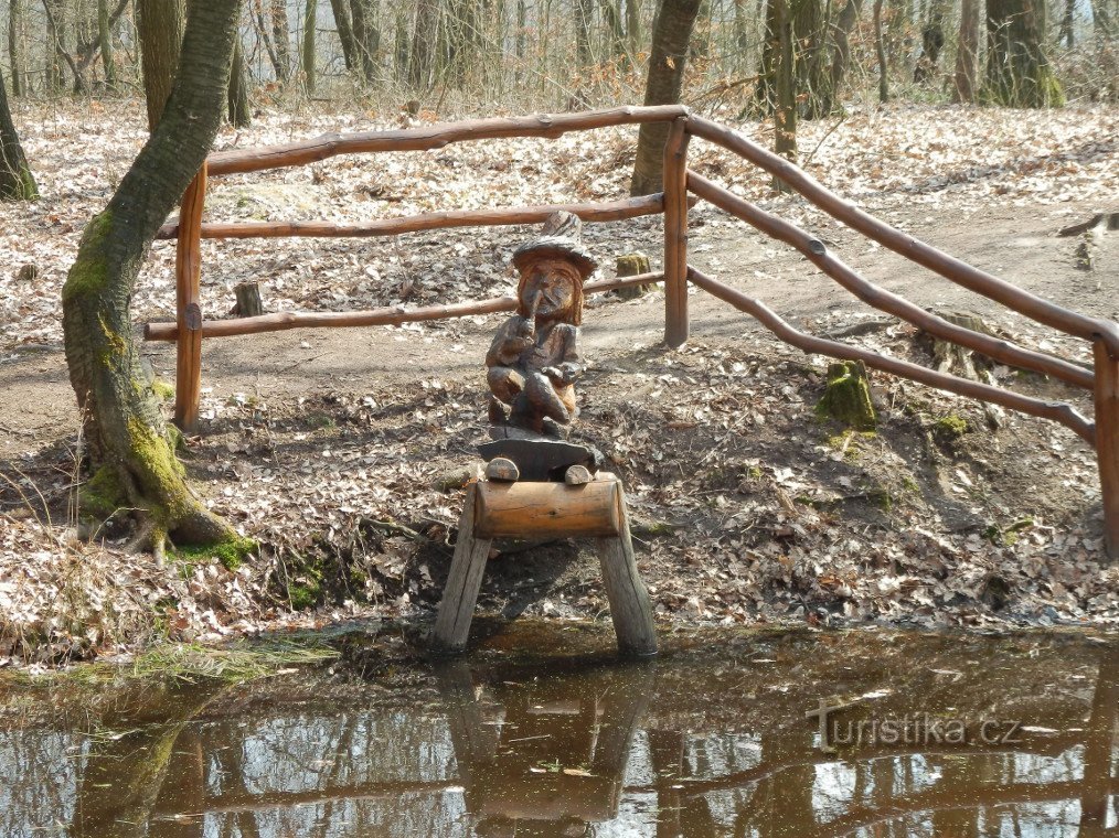 Am Ufer des Teiches sitzt ein Wasservogel