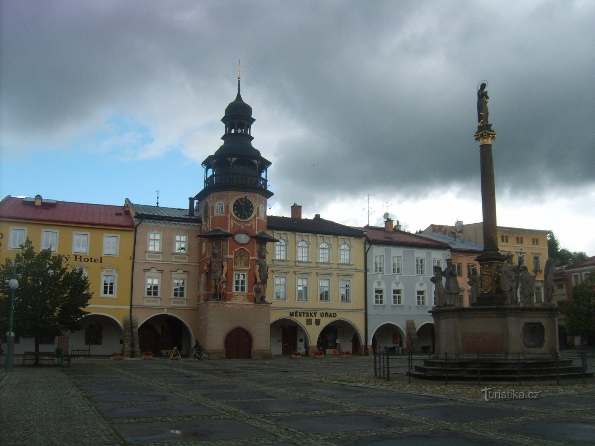 la plaza con la torre del ayuntamiento y la columna de la peste