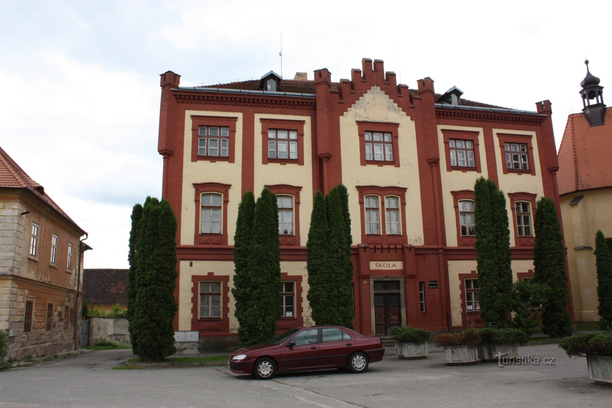Novogotická budova staré školy v Netolicích v sousedství kostela sv. Václava