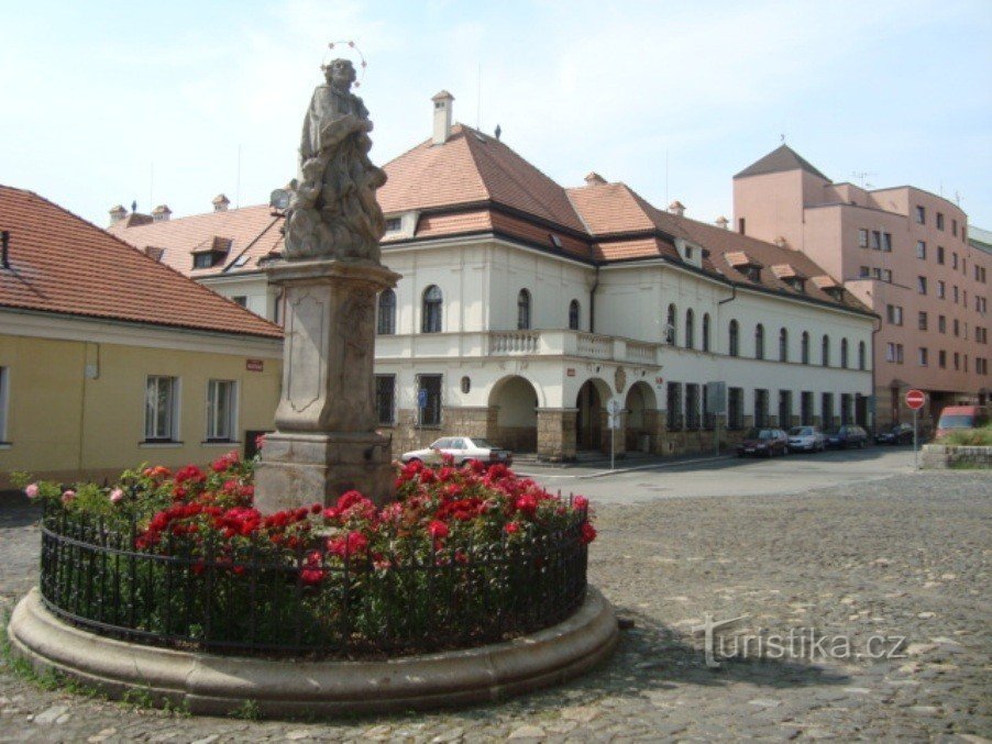 Nymburk-kerkplein met het standbeeld van St. Vojtěch en het stenen huis-Foto: Ulrych Mir.