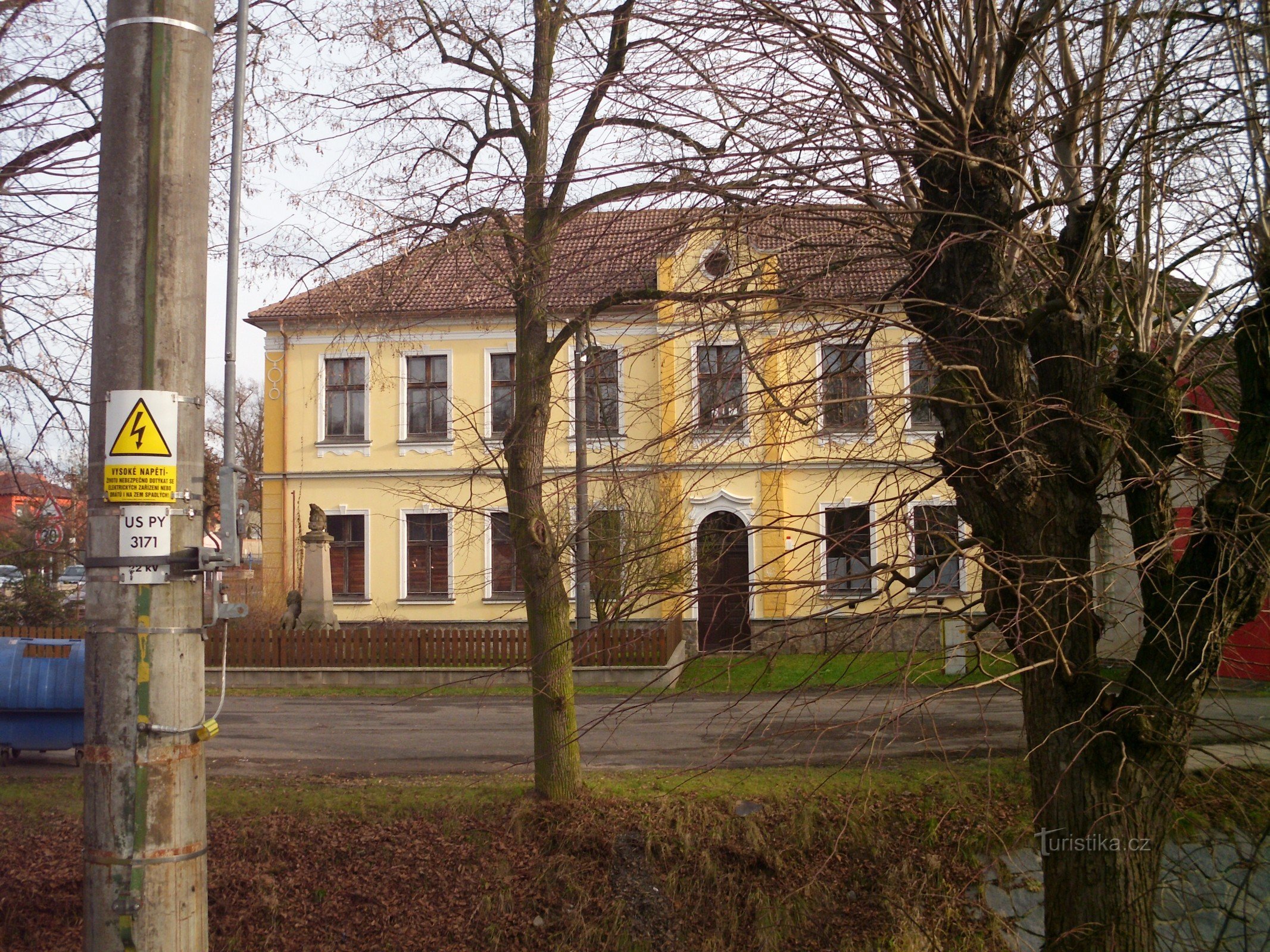 Kommunehus med et monument bag åen